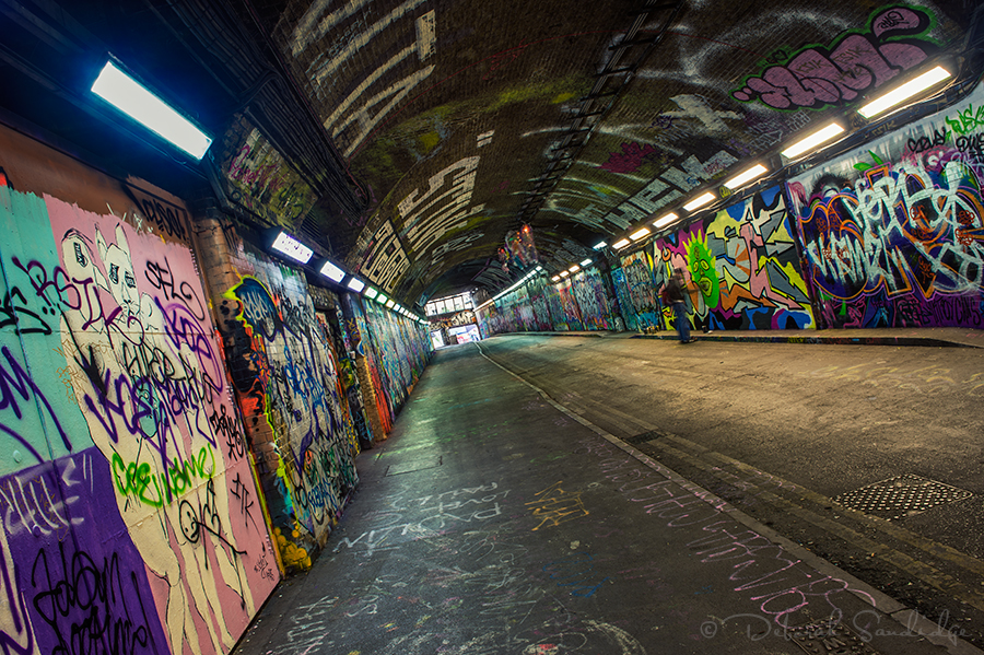 Dark tunnel of London Graffiti with artist painting