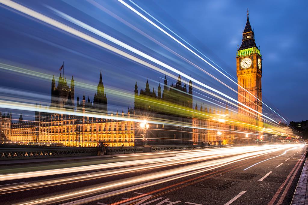 Big ben at twilight with streaks of light from passing bus.